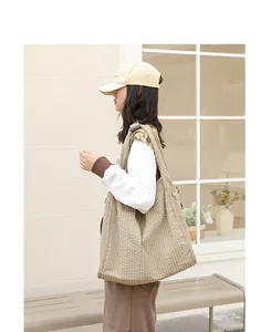 Bolso tote de cuadros estilo coreano lucido por una modelo en entorno exterior