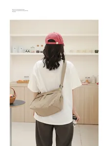 Rückansicht einer lässigen khakifarbenen Nylon-Umhängetasche für Damen im Café