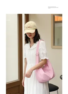 Casual pink pleated nylon shoulder bag worn by a model in a white dress and beige cap
