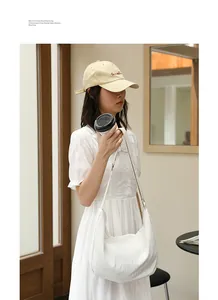 Detailed lifestyle view of a white pleated nylon crossbody bag in mori style