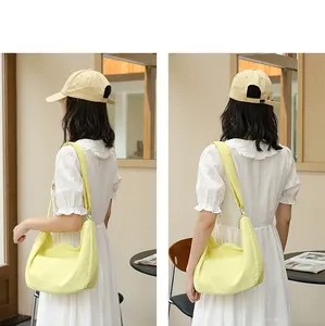 Fashionable yellow pleated nylon shoulder bag shown from side and back on a model