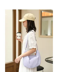 Asian model wearing a stylish lavender crinkle nylon shoulder bag in a casual indoor setting