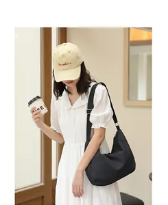 Model wearing the black pleated nylon shoulder bag in a lifestyle setting