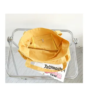 Detailed interior view of a yellow canvas tote bag featuring a secure zipper pocket