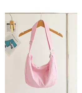Detailed view of the crinkled texture on a pink nylon hobo bag hanging on a rack.