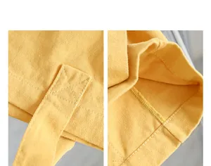 Detailed macro view of yellow washed canvas tote bag stitching and interior seam.