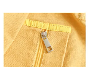 Detailed macro view of a durable silver metal zipper on yellow canvas tote bag