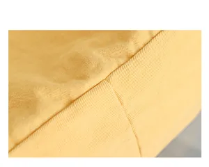 Detailed close-up of yellow canvas fabric and stitching for a vintage style tote bag