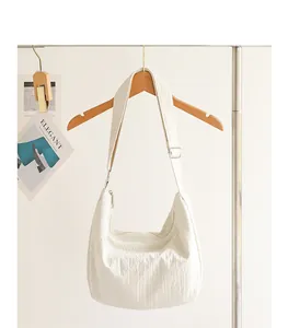 Detail view of stylish white pleated nylon hobo bag with an adjustable shoulder strap