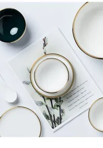 Dettaglio del set di piatti in ceramica verde smeraldo con elegante bordo oro