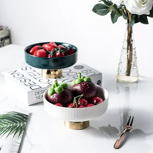 European luxury ceramic fruit bowl set with gold pedestal on a white marble table