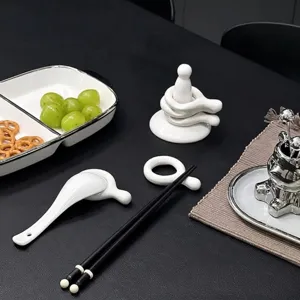 Minimalist white ceramic chopstick rests and spoon holders on a dining table setting
