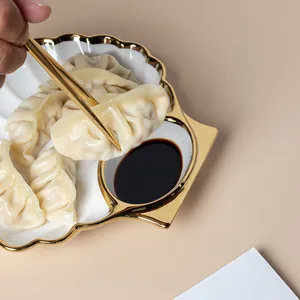 Elegante plato para dumplings de cerámica blanca con borde dorado y cuenco para salsa