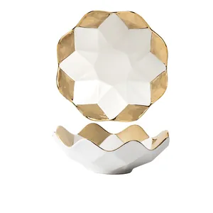 Elegante weiße und goldene Keramik-Obstschale mit geometrischen Facetten und Wellenrand