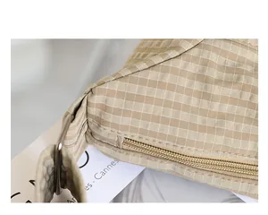 Primer plano macro de un bolso hobo de lona a cuadros con cremallera y textura de tela