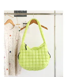 Detailed view of a lime green quilted nylon shoulder bag on a garment rack.