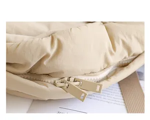 Primer plano del detalle de cremallera doble en mochila de nailon beige