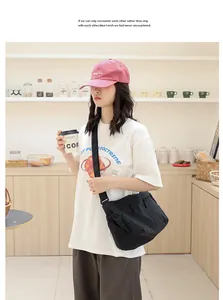 Detailaufnahme einer lässigen schwarzen Kurier-Tasche aus Nylon in einem Café-Ambiente.