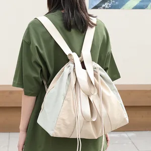 Mochila casual de nailon bicolor con cordón para mujer en un entorno de estilo outdoor