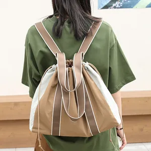 Mochila y bolso tote casual de lona en bloques de color con cordón usado por una modelo.