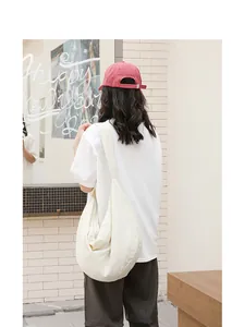Rückansicht eines Modells mit einer cremeweißen Hobo-Tasche mit Waffelstruktur in der Stadt
