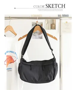 Schwarze minimalistische japanische Canvas-Umhängetasche mit breitem Gurt am Ständer