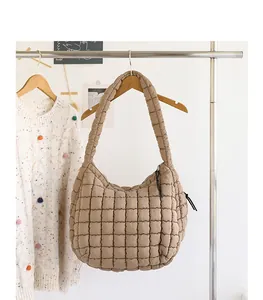 Detailed macro view of khaki quilted nylon hobo bag featuring fashionable puffer grid pattern