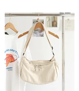 Lässige beige Nylon-Umhängetasche an einem Ständer in minimalistischer Umgebung