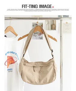 Lässige beige Nylon-Umhängetasche an einer Kleiderstange in einem minimalistischen Zimmer