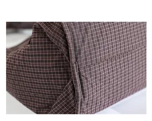 Primer plano de la tela a cuadros y costuras de un bolso de mano de nailon marrón