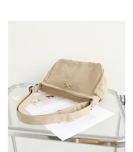 Detailansicht einer minimalistischen beigen Nylon-Umhängetasche mit Reißverschluss.