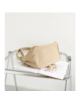 Detaillierte Unteransicht einer minimalistischen beigen Nylon-Umhängetasche auf einem Tablett