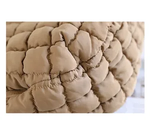 Macro close-up of the quilted and pleated nylon fabric texture of the handbag