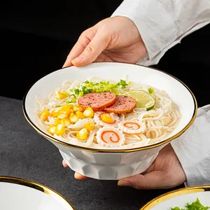 White Japanese ceramic ramen bowl with gold rim holding delicious noodles and soup