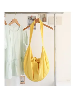 Detail der gelben Crossbody-Tasche mit Blasenstruktur hängend an Kleiderstange