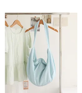 Detail eines hellblauen Hobo-Dumpling-Bag mit Blasenstruktur an einem Kleiderständer