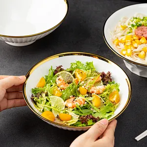 Elegant white Japanese style ceramic ramen bowl with gold rim and pleated exterior texture