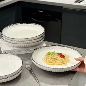 Assiettes élégantes en céramique blanche avec bord argenté et texture côtelée en cuisine