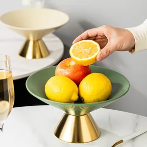 Elegant modern ceramic fruit bowl with golden pedestal base for luxury living room decor
