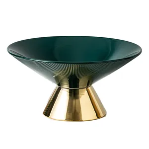 Luxurious modern dark green ceramic fruit bowl with an elegant gold-finished high pedestal base
