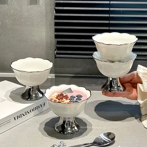 Eleganter weißer Keramik-Nachtischteller mit Wellenrand und silbernem hohem Fuß