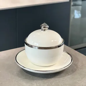 Elegante olla de cerámica blanca con tapa y platillo con diseño de borde plateado