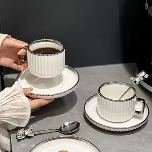 Elegante juego de tazas de café de cerámica con borde plateado y cuchara de oso para té.