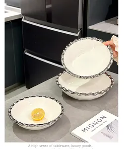 Vue détaillée de bols en céramique blanche avec bordure argentée ondulée de luxe.