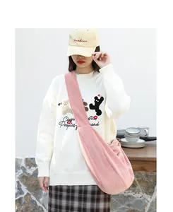 Bolso bandolera de pana rosa tipo dumpling mostrado por una modelo en estilo japonés
