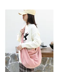 Detalle de primer plano de un bolso de pana rosa con textura suave y diseño espacioso