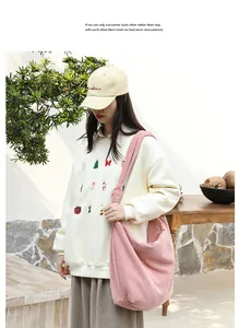 Large pink corduroy shoulder bag with knot strap detail shown on a female model