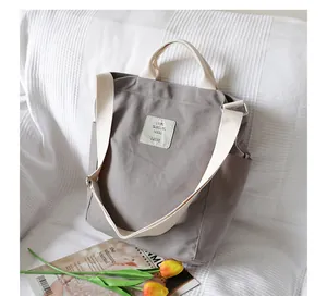 Casual gray canvas tote bag featuring off-white straps and a front logo patch for women
