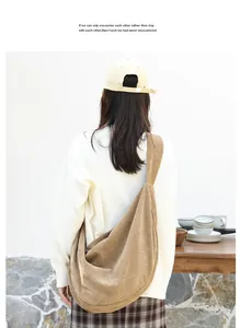 Vista detallada de un bolso grande de pana caqui en una modelo con atuendo informal