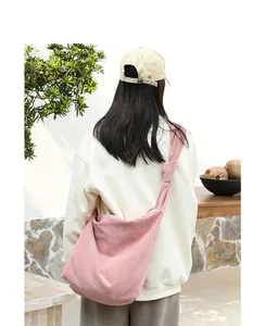 Pink corduroy crossbody bag with stylish knot strap detail on female model